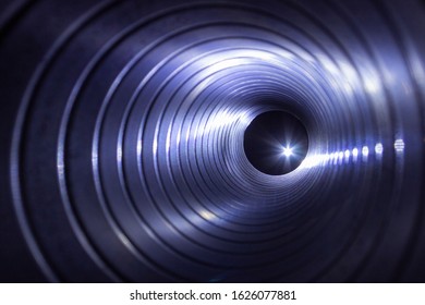 Closeup View From Inside The Galvanized Steel Air Duct On The Exhaust Fan In The Background Light, The Front And Back Background Is Blurred With A Bokeh Effect