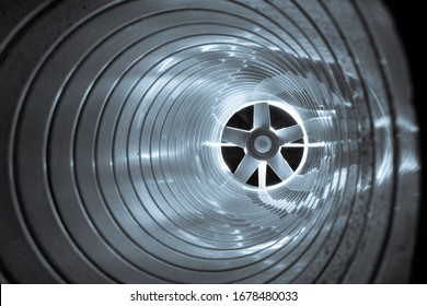 Closeup View From Inside The Galvanized Steel Air Duct On The Exhaust Fan In The Background Light, The Front And Back Background Is Blurred With A Bokeh Effect