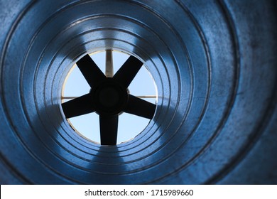 closeup view from inside the galvanized steel air duct on the exhaust fan in the background light, the front and back background is blurred with a bokeh effect