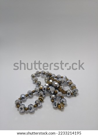Closeup view of Islamic prayer beads made from silver painted plastic isolated on white background.
