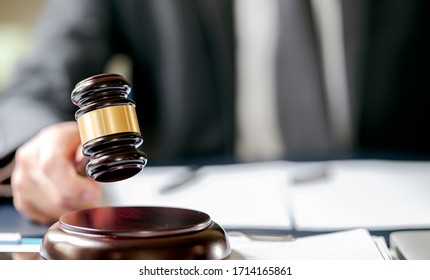 Closeup View Of  Judge Hand Holding Gavel To Bang On Sounding Block In The Court Room.