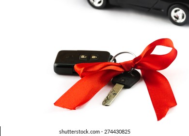 Close-up View Of Keys With Red Bow And Car As Present On White Background