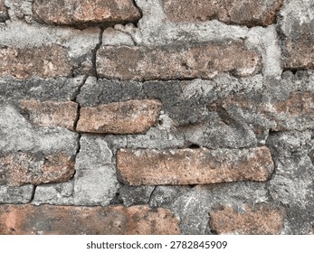 Close-up view of a large, deep crack splitting through an old weathered brick and concrete wall texture, showing significant wear and grunge detail.