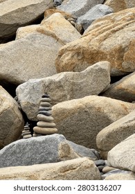 Close-up view of large, piled rocks resting on the riprap shoreline structure in Carlsbad, California.