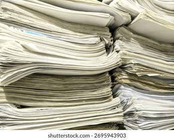 A close-up view of a large stack of old documents and papers piled together in disorganized layers.