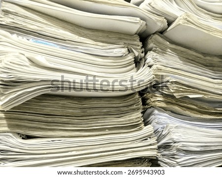 A close-up view of a large stack of old documents and papers piled together in disorganized layers.