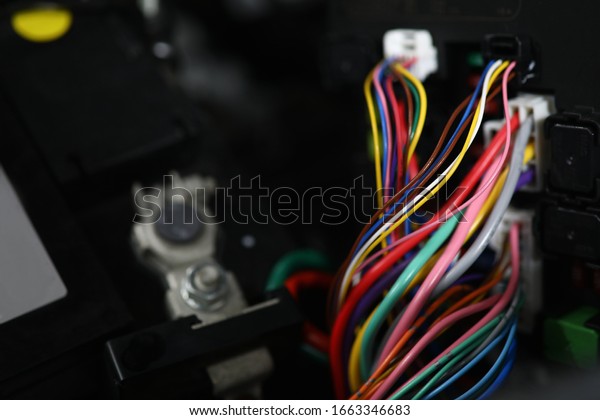 Close-up view of large wide\
cable with multicolored wires and connectors. Electric connector\
plug of car engine. Service center for automobile repair\
concept