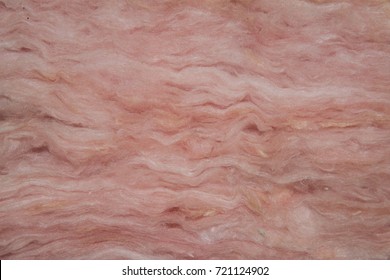 Closeup view of layers of pink fiberglass insulation. 
