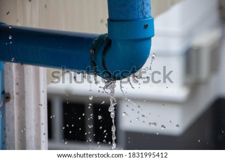 Closeup view of leaked and splash water from the plastic pipe during the rainy day after storm