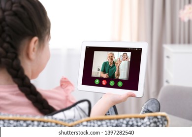 Closeup view of little girl talking with grandfather via video chat at home  - Powered by Shutterstock