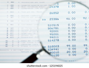 Closeup view of magnifying glass looking at financial report