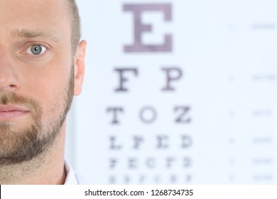 Closeup View Of Man And Blurred Eye Chart On Background. Space For Text