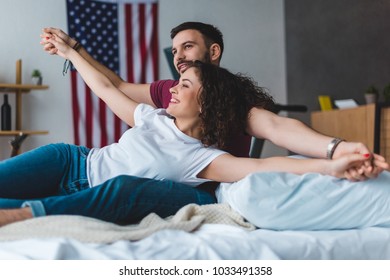 Closeup view of man holding hands of girlfriend on bed - Powered by Shutterstock