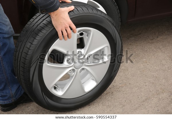 Closeup view of man\
rolling wheel outdoors