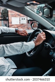 A Closeup View Of A Man With A Shirt Driving A Car On A Sunny Day