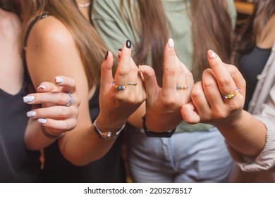 Close-up View Of A Man's Hand Showing A Ring With An LGBT Rainbow Wristband.