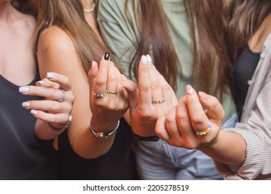 Close-up View Of A Man's Hand Showing A Ring With An LGBT Rainbow Wristband.