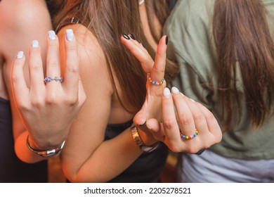 Close-up View Of A Man's Hand Showing A Ring With An LGBT Rainbow Wristband.