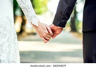 Closeup view of married couple holding hands 
