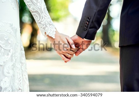 Closeup view of married couple holding hands 