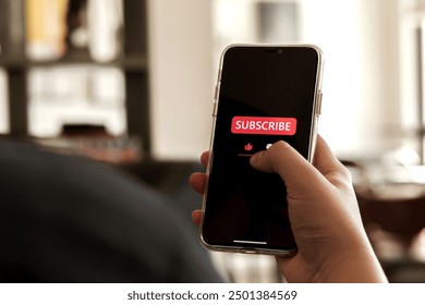 Close-up view of men using a smartphone to press red subscribe button on online media. Concepts of technology and following news, hot trends and new content on social media - Powered by Shutterstock