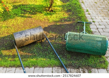 Close-up view of mesh soil roller and traditional lawn roller for leveling and compacting soil in garden. Sweden.