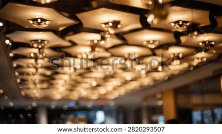 A close-up view of a modern ceiling with multiple hexagonal light fixtures emitting a warm, inviting glow.