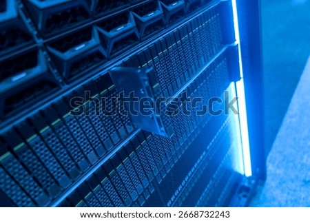Close-up view of a modern data storage unit illuminated by blue light, showcasing intricate components and technology that enhance data management and performance.
