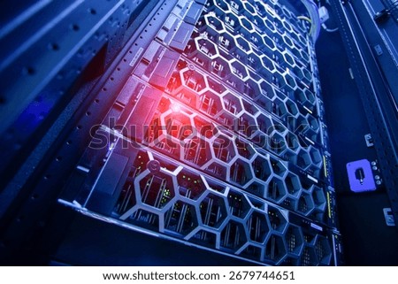 A close-up view of a modern server rack featuring a unique hexagonal design illuminated by blue lights, showcasing advanced technology and data processing capabilities.