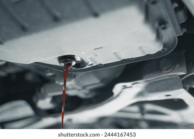 Close-up view of motor oil being drained from a car during a routine oil change service.
 - Powered by Shutterstock