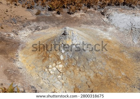 Close-up view of a mud volcano cone with mineral deposits and cracked geothermal clay, in Uzon Caldera, Kamchatka Krai, Russia, volcanic landscape