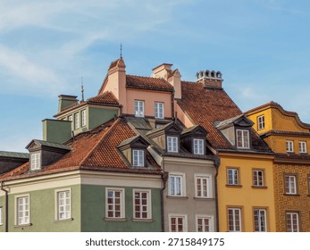 Close-up view of the multi-colored rooftops and dormer windows of historic tenement houses in Old Town Warsaw.