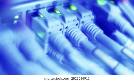 Close-up view of multiple Ethernet cables connecting to a server switch, pulsating with green indicator lights.