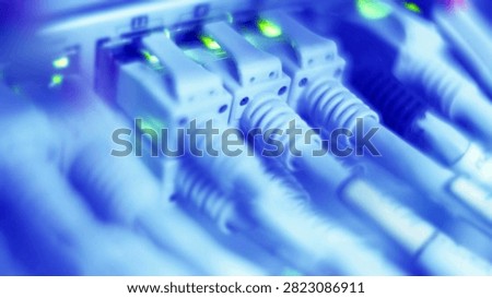 Close-up view of multiple Ethernet cables connecting to a server switch, pulsating with green indicator lights.