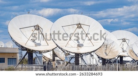 Close-up view of multiple large satellite dishes at a ground telecommunication station 