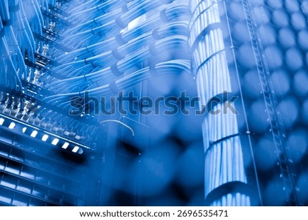 A close-up view of network cables in a server room, showcasing intricate wiring and blue lighting. Ideal for technology and data-related visuals.