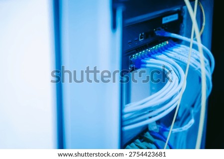 A close-up view of network cables in a server rack highlights modern technology and infrastructure for data management and communication systems.