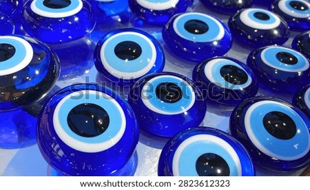 A close-up view of numerous blue evil eye charms, symbolizing protection against bad luck and negative energy.