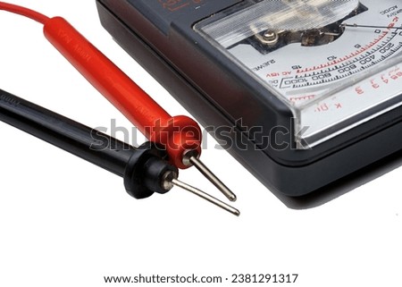 A close-up view of an ohm meter with red and black probes isolated on white.