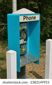 A close-up view of an old blue phone booth.