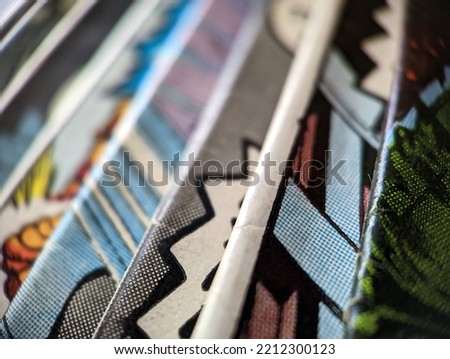Closeup view of an old comic book collection creates a colorful background paper texture with abstract shapes
