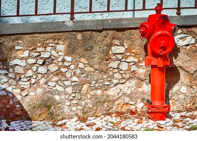 Closeup View of Old Styled Red Fire Cock Hydrant Against of Wall Located On One of The Streets in Portugal. Horizontal Image Composition