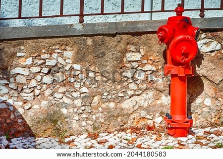Closeup View of Old Styled Red Fire Cock Hydrant Against of Wall Located On One of The Streets in Portugal. Horizontal Image Composition