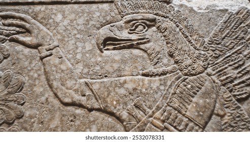 Close-up view on Eagle-headed Winged Figure And Sacred Trees. Architectural Fragment Of Panel From Northwest Palace Of Ashurnasirpal Ii By Neo Assyrian Period. Winged Bird Divine Spirit. Symbol Of
