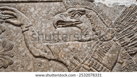 Close-up view on Eagle-headed Winged Figure And Sacred Trees. Architectural Fragment Of Panel From Northwest Palace Of Ashurnasirpal Ii By Neo Assyrian Period. Winged Bird Divine Spirit. Symbol Of