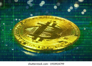 Close-up view on metal physical bitcoin cryptocurrency. BTC placed on top of the motherboard chip. Lots of connections slots and electronical elements around. Binary code with green gradient in the bg