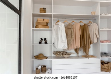 Closeup view on minimalistic modern scandinavian white wood walk in closet with wardrobe in neutral beige colors