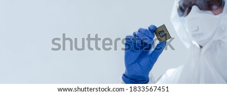 Close-up view on a new semiconductor microchip in gloved hand of computer scientist. Modern technology and hardware development