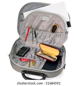 Close-up view to opened suitcase with accessories on white background. Studio shot, not isolated.