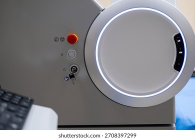 A close-up view of the operational control panel on the main unit of the ZEISS VISUMAX 800 Femtosecond Laser System, featuring the emergency stop, key lock, and a prominent illuminated housing